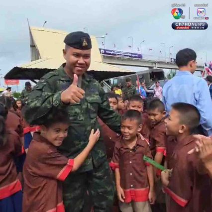 นักเรียนโบกธงชาติไทย ทักทายให้กำลังใจพี่ทหารที่ขับรถผ่านมา ระหว่างจะไปทำภารกิจที่ชายแดนไทย-กัมพูชา