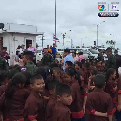 นักเรียนโบกธงชาติไทย ทักทายให้กำลังใจพี่ทหารที่ขับรถผ่านมา ระหว่างจะไปทำภารกิจที่ชายแดนไทย-กัมพูชา