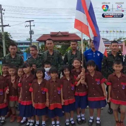 นักเรียนโบกธงชาติไทย ทักทายให้กำลังใจพี่ทหารที่ขับรถผ่านมา ระหว่างจะไปทำภารกิจที่ชายแดนไทย-กัมพูชา